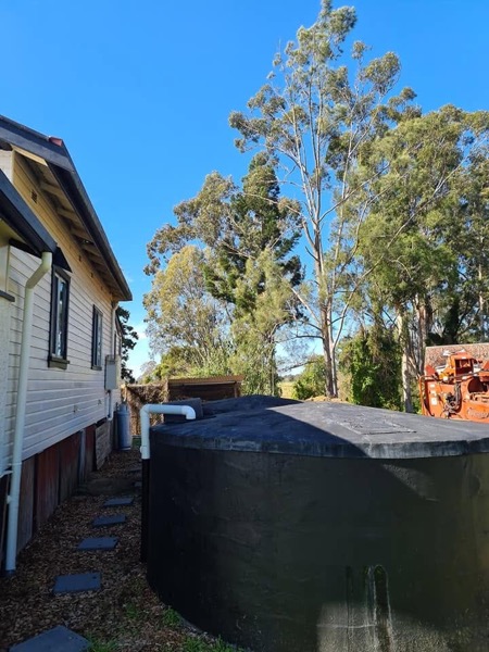 Tight side access beside a water tank and house