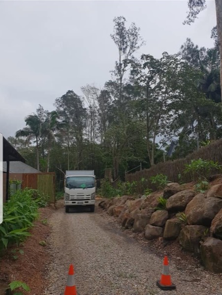 The truck backing down a rock-walled driveway