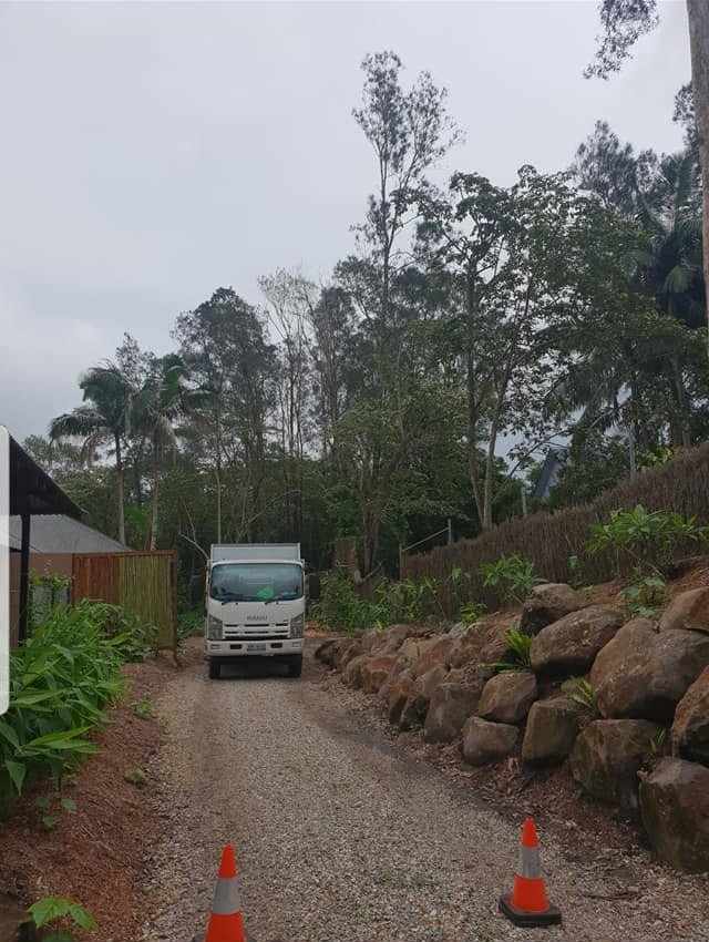 The truck backing down a rock-walled driveway